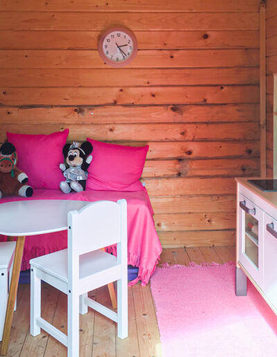The child friendly garden with apple trees and playhouse.