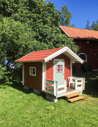 The child friendly garden with apple trees and playhouse.